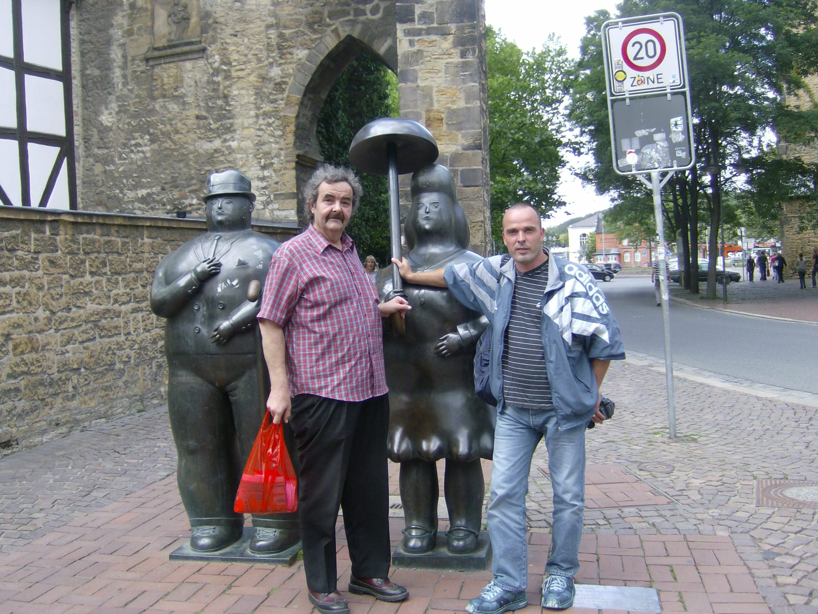 Farbfoto: Die Plastiken MANN MIT STOCK und FRAU MIT ALTEM SCHIRM von dem Künstler Fernando Botero vor dem Rosentor in Goslar im August des Jahres 2011. Fotograf: Ralph Ivert.