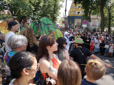 Farbfoto von Menschen, die auf Stelzen gehen auf dem Umzug vom Karneval der Kulturen auf der Straße Hasenheide in Berlin am 28. Mai 2023. Fotograf: Erwin Thomasius.