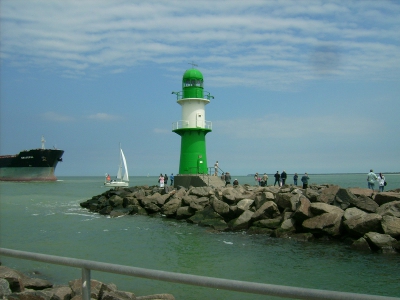 Farbfoto: Auf der Mole in Warnemünde im Juni 2009. In der Einfahrt zum Hafen ein Segelboot und der Massengutfrachter GRACEFUL. Fotograf: Bernd Paepcke.