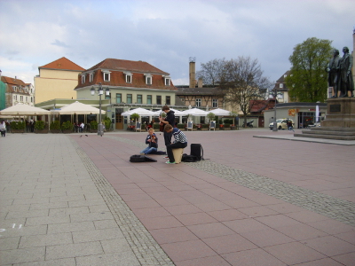 Farbfoto: Junge Strassenmusikanten vor dem GOETHE- UND SCHILLER-DENKMAL auf dem Theaterplatz in Weimar im Jahre 2012. Fotograf: Bernd Paepcke.